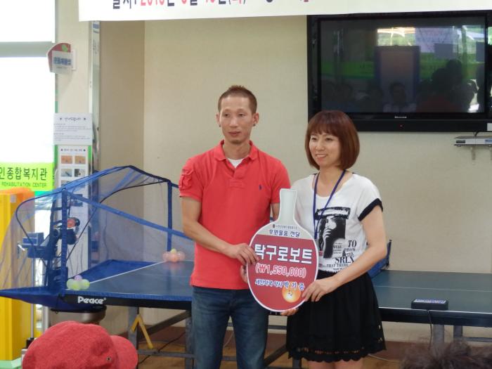 박기준 약사가 장애인종합복지관에 탁구연습로부트를 기증하고 기념사진을 찍고 있다.