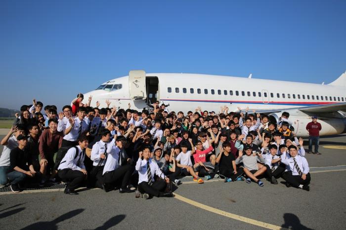 보잉 737기 앞에서 포즈를 취하는 학생들