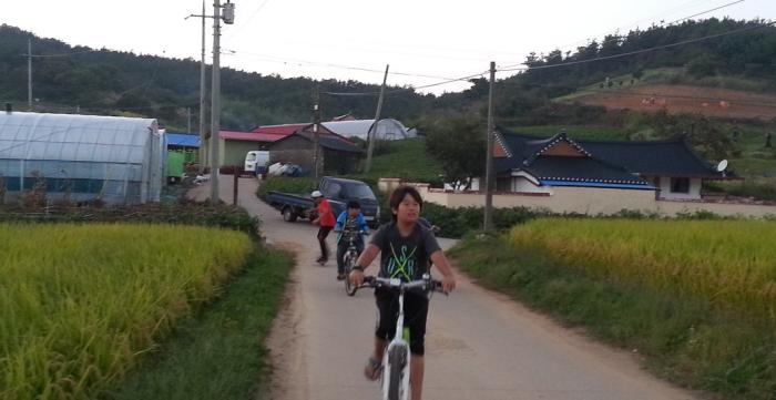 잘 정비된 마을 안길을 자전거를 타고 달리는 아이들